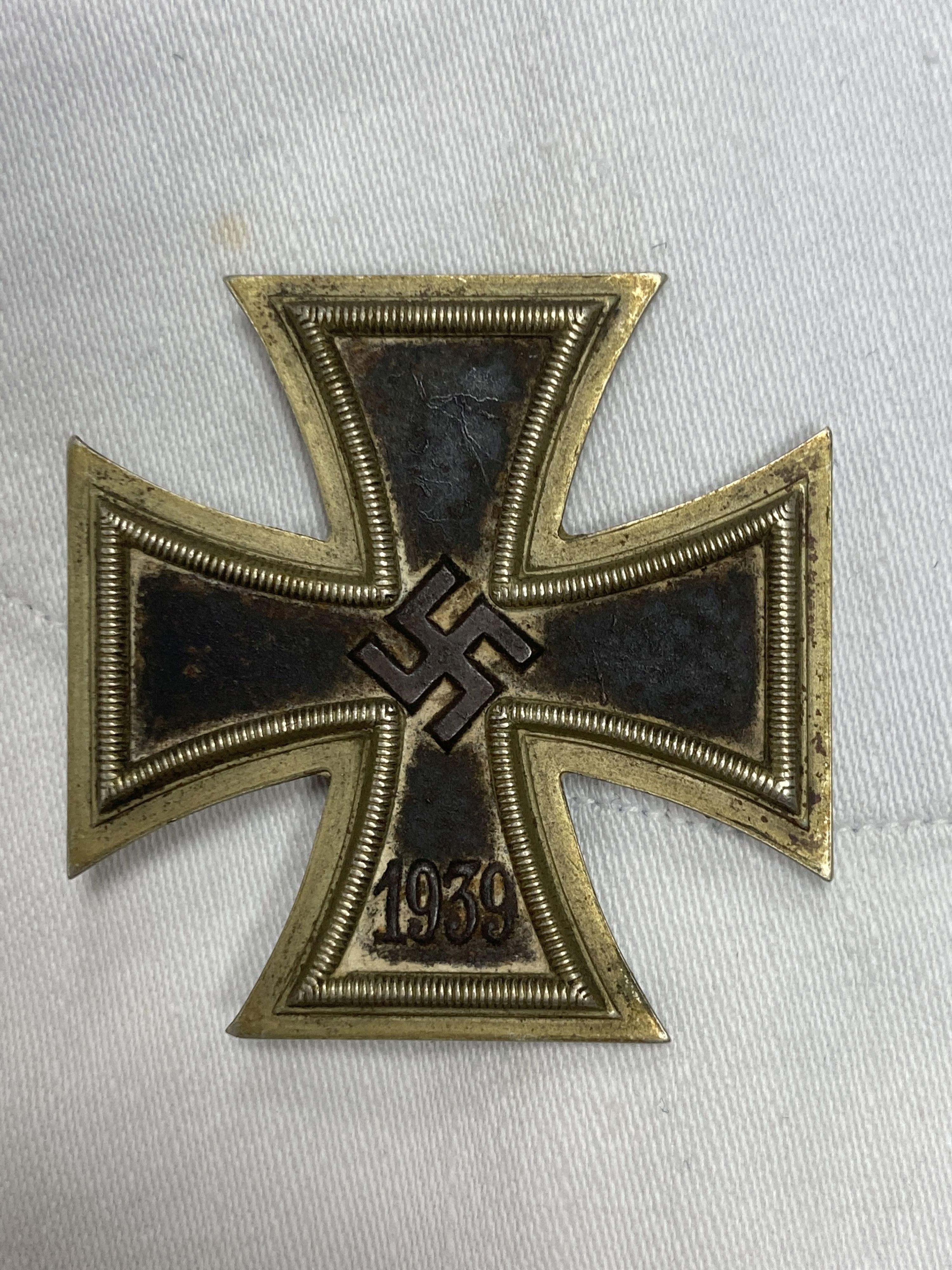 Two German  period white naval tunics, one named 'Schmidt. R, X176 T', together with an associated 1939 iron cross (3)